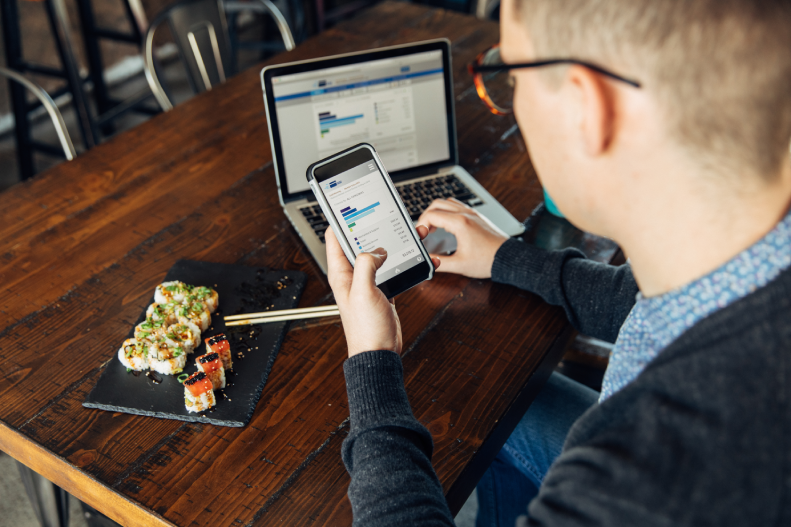 Guy investing while eating sushi