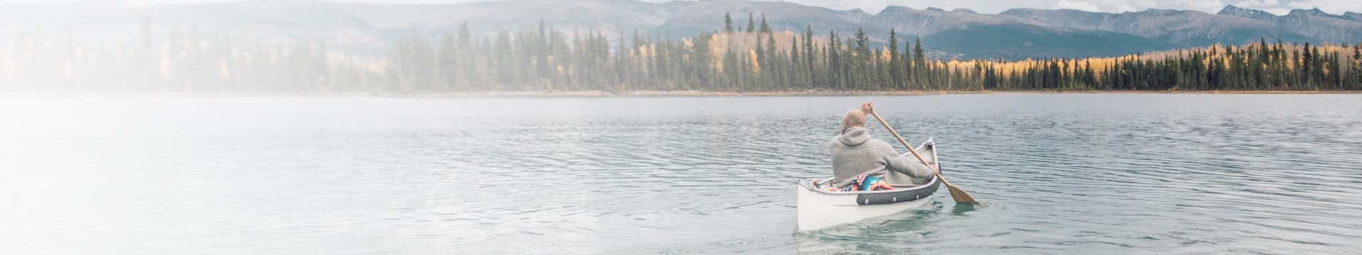 Un homme qui pagaie sur un lac