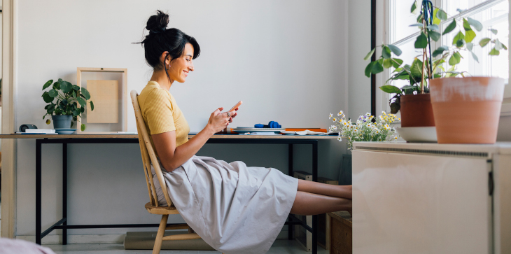 Lady checking her phone to discover costs associated to homeownership