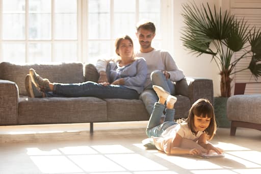 Couple watching their daughter read a book